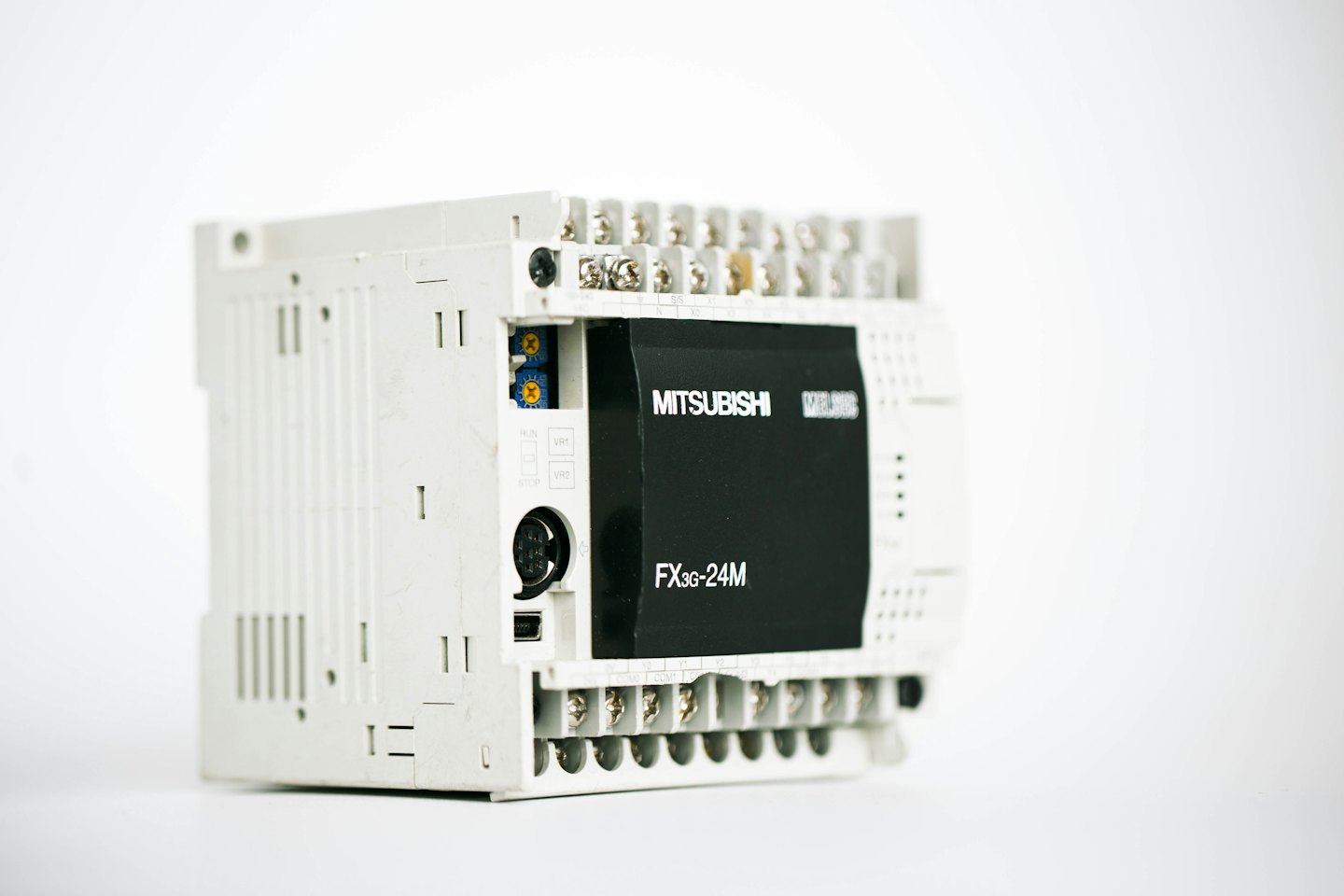 White and black industrial programmable logic controller unit with terminals and text.